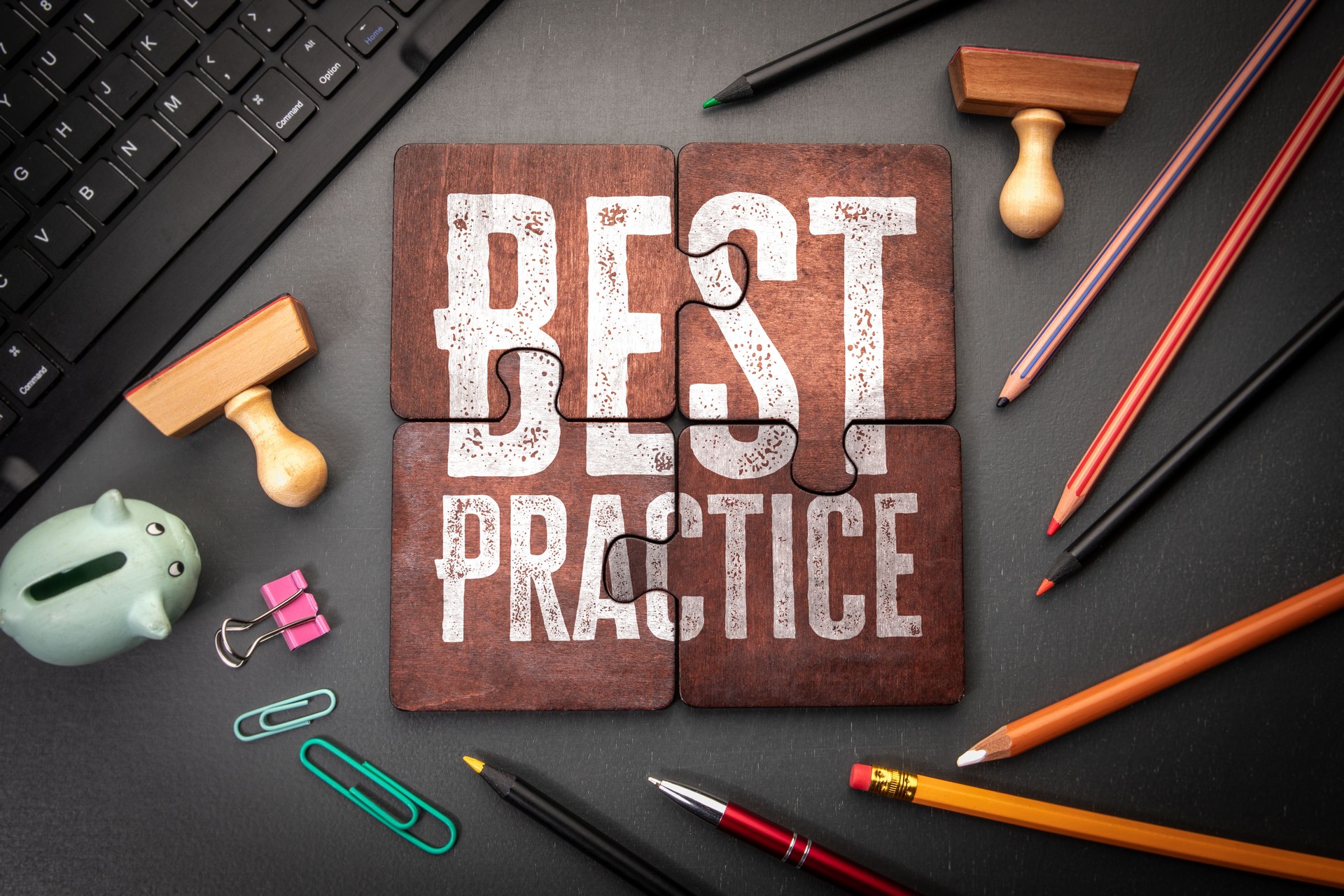 Best Practice Concept Displayed on Puzzle Pieces Surrounded by Office Supplies and Workspace Tools